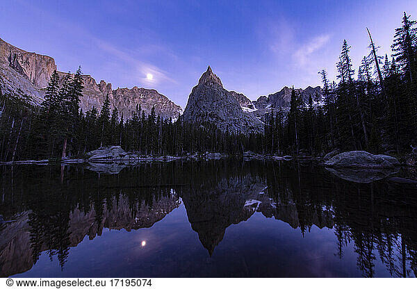 Reflection of Lone Eagle Peak on Mirror Lake against sky at dusk