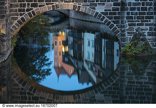 Reflection of residential houses around Pegnitz river and arch of bridge at Henkerhaus Museum  Nuremberg  Germany