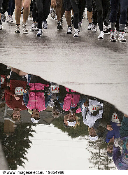 Reflection of runners in puddle in Seattle  Washington.