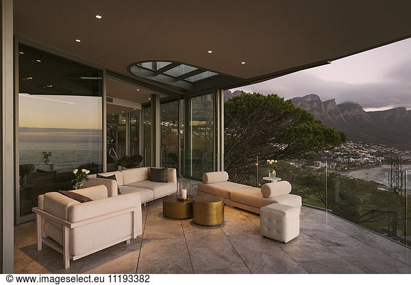 Reflection of twilight ocean view on modern luxury home showcase patio with mountain view