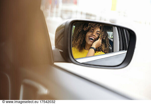 Reflection of woman in side-view mirror of car