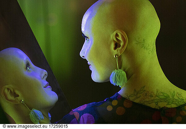 Reflexion stilvolle Frau mit rasiertem Kopf und Tattoos
