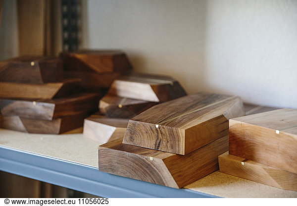 Regale in einer Drechslerwerkstatt und eine Ausstellung glatter Holzplatten.