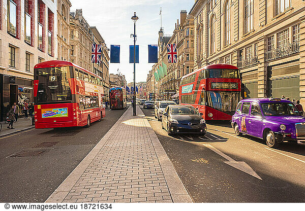 Regent street late afternoon with London red buses and taxis