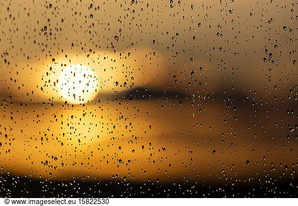 Regentropfen auf ein Fenster bei Sonnenuntergang