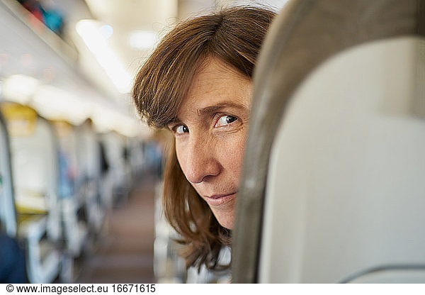 Reife Frau auf Flugzeugsitz