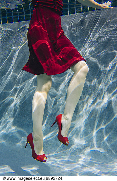 Reife Frau in rotem Kleid und High Heels  Unterwasseransicht  tiefer Schnitt