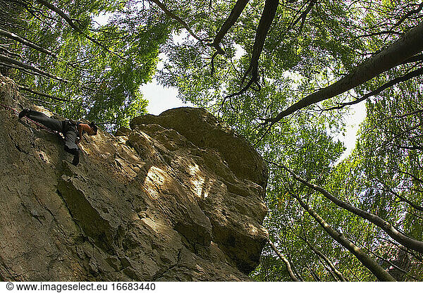 Reife Frau klettert auf Kalksteinfelsen in Norddeutschland
