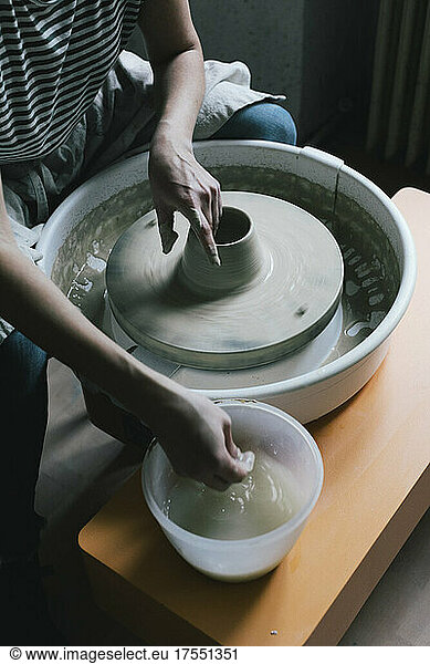 Reife weibliche Besitzerin modelliert Form für Topf in Keramikgeschäft