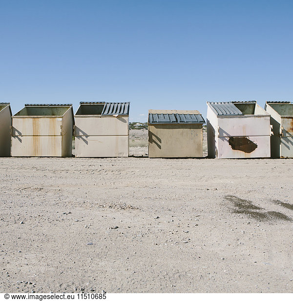 Reihe von Müll- und Recycling-Behältern in der Wüste