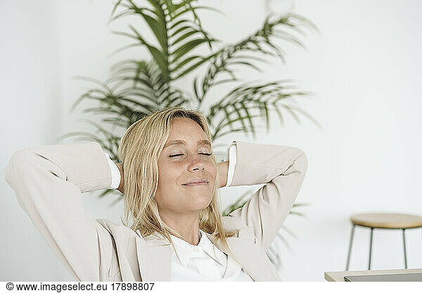 Relaxed businesswoman with closed eyes in office