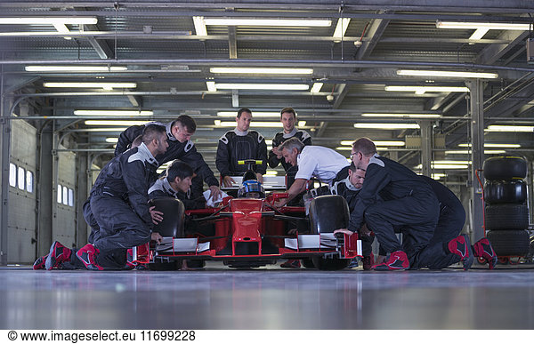 Rennwagen-Team bei der Arbeit am Rennwagen in der Garage