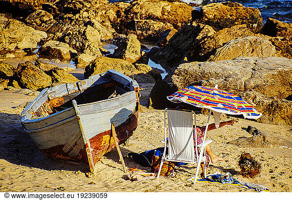 Report Illegal migration from Morocco to Spain. People from Africa are trying to get to the territory of the European Community (today: European Union) for a variety of reasons. A large proportion of immigrants attempt the sea route from Morocco to Spain  using small keelless wooden boats ( pateras ) with outboard motors. Some also try to hide on ferries from Morocco to Algeciras (Spain).
Here: Tourist on the beach of Tarifa. Next to it a wooden boat abandoned by illegal immigrants.
Tarifa (Spain)  1993.