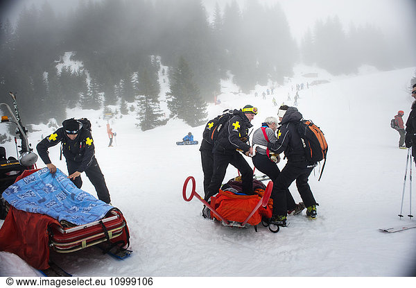 Reportage with a ski patrol team at the Avoriaz ski resort in Haute Savoie  France. The team are responsible for marking out the ski slopes  providing first aid to skiers  evacuations on the slopes as well as off piste and controlled avalanches. The patrol team evacuate a skier who has a shoulder injury.