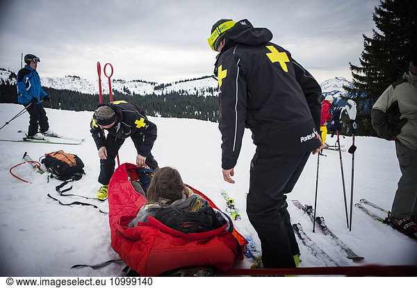 Reportage with a ski patrol team at the Avoriaz ski resort in Haute Savoie  France. The team are responsible for marking out the ski slopes  providing first aid to skiers  evacuations on the slopes as well as off piste and controlled avalanches. The patrol team evacuate a woman who has a shoulder injury.
