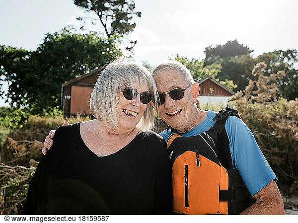 retired couple laughing at the beach ready to do water sports