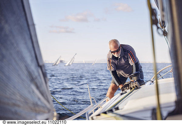 Retired man sailing sailboat