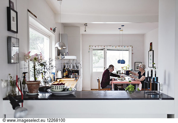 Retired senior couple eating food at dining table