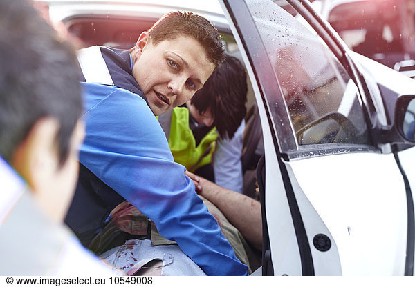 Rettungskräfte ziehen Autounfallopfer aus dem Auto