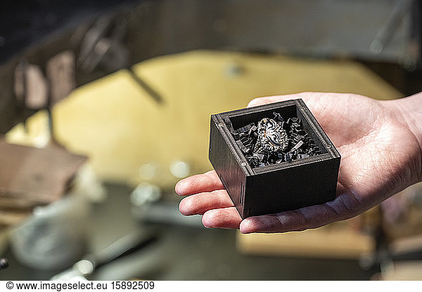 Ring in a jewelry box  hand of female goldsmith in her workshop
