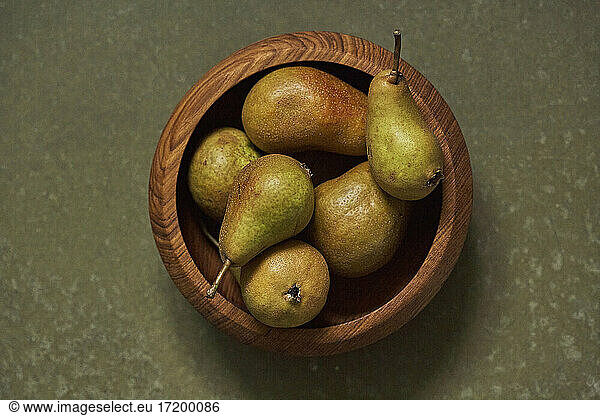 Ripe pears in wooden bowl