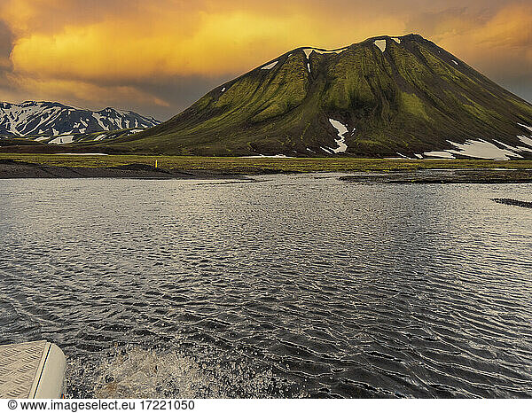 Rippled lagoon in front of volcano during sunset