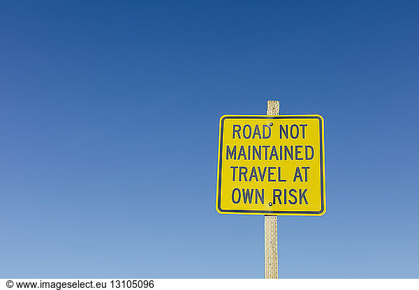 Road Not Maintained - Travel at Own Risk sign along remote desert road