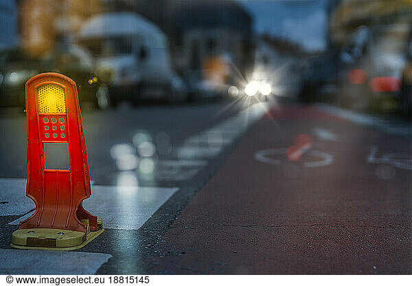 Road reflector in front of bicycle lane at dusk