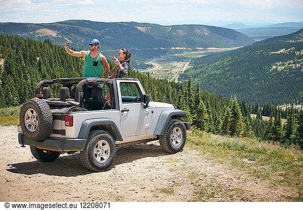 Roadtrip eines Paares in geparktem Vierrad-Cabriolet mit Selbstfahrer in den Rocky Mountains  Breckenridge  Colorado  USA