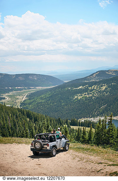 Roadtrip-Paar  das von der Motorhaube eines Geländewagens auf Berge schaut  Breckenridge  Colorado  USA