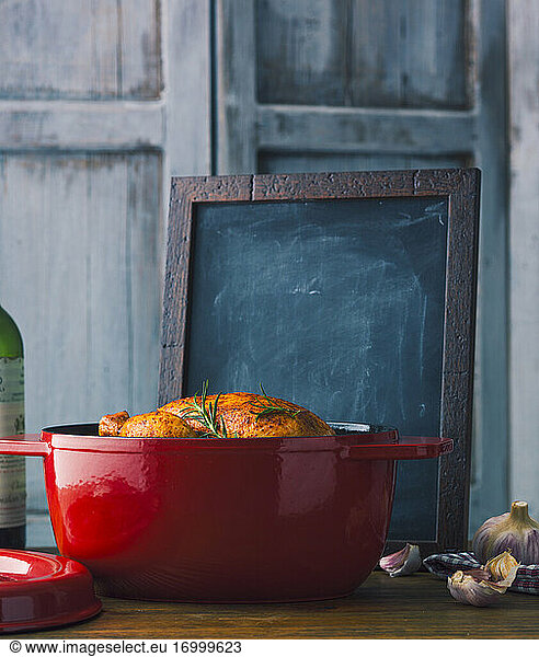 Roasted chicken in red cast iron pot