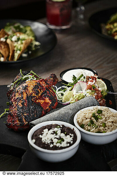 Roasted half chicken with black beans  rice and tortillas.