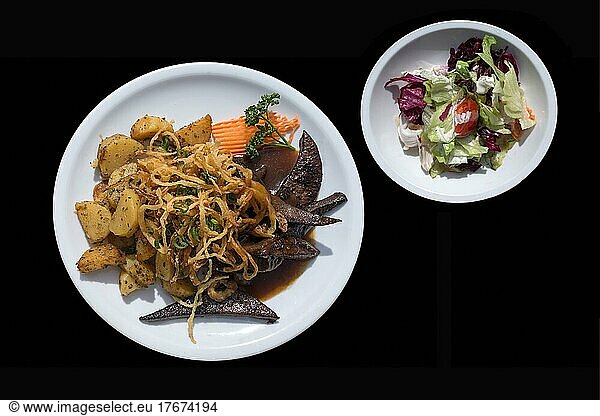 Roasted pork liver with fried onions and fried potatoes with mixed salad plate  on black ground  Franconia  Bavaria  Germany  Europe