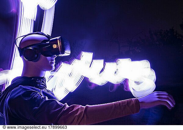 Robot wearing virtual reality simulator standing by light trail