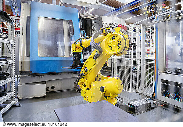 Robotic arm in front of machine