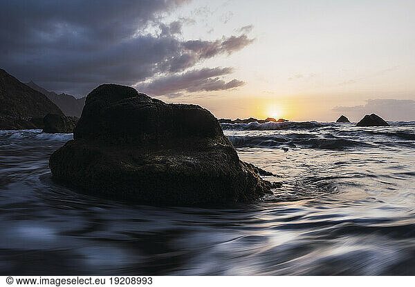 Rock amidst sea at sunset in Playa de Benijo
