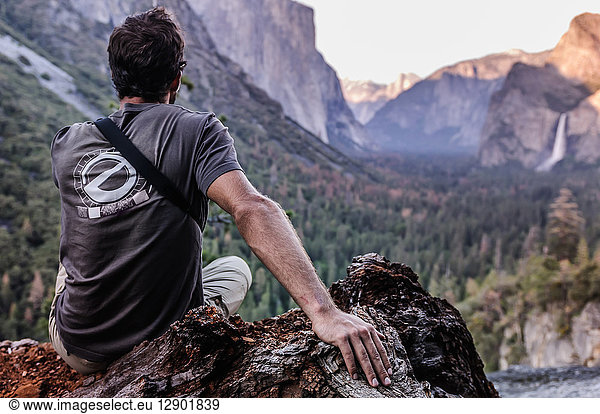 Rock climber looking out at mountain ranges  Yosemite National Park  California  USA