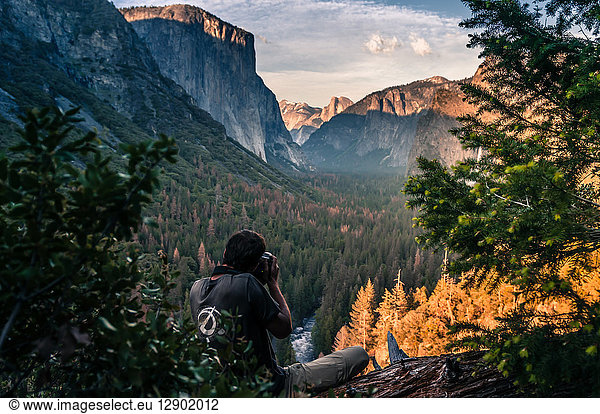 Rock climber taking photograph of mountain ranges  Yosemite National Park  California  USA