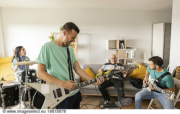 Rock musicians practicing together with musical instruments at home