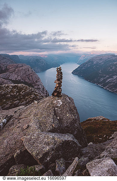 Rock pile and view of Norwegian fjords in cloudy day