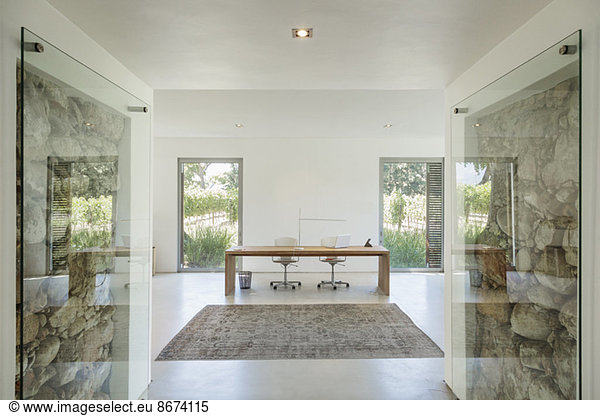 Rocks behind glass in wall of modern home office