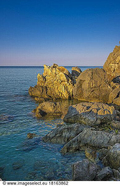 Rocks on coastline at sunset
