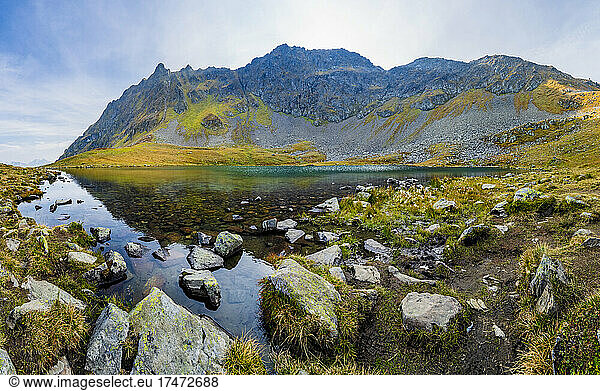 Rocky shore of Herzsee lake in Otztal Alps during autumn