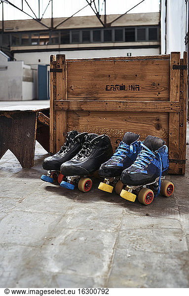 Roller skates against wooden box on sports court