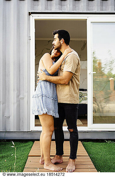Romantic couple embracing outside container home
