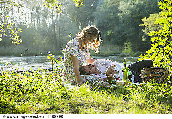 Romantic couple enjoying picnic by lake  Germany