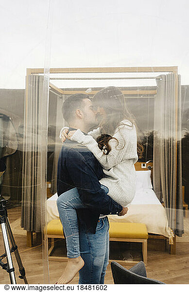 Romantic couple kissing inside dome hotel