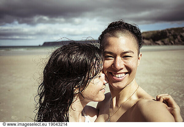 Romantic happy selfie by lesbian couple on beach