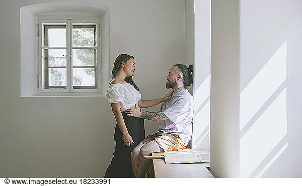 Romantic hipster couple by wall at home