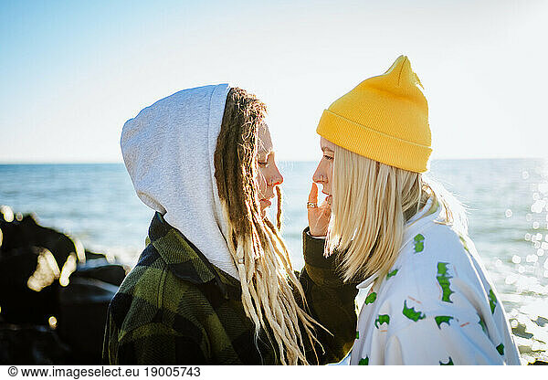 Romantic lesbian couple standing near sea